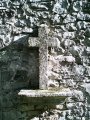Petite croix implante dans le mur d'une habitation sur la route de la gare,  la sortie de LAISSAC sur la D28 (Axe reliant LAISSAC  SEVERAC L'EGLISE)